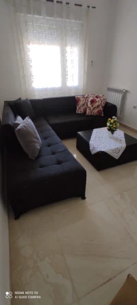 Canapé en L avec une table basse et 7 coussins 