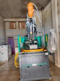 Machine d'injection plastique verticale de type rotatif à deux stations.