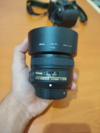 Nikon nikkor 50mm 1.8 avec 2 bouchon ett parasolei 