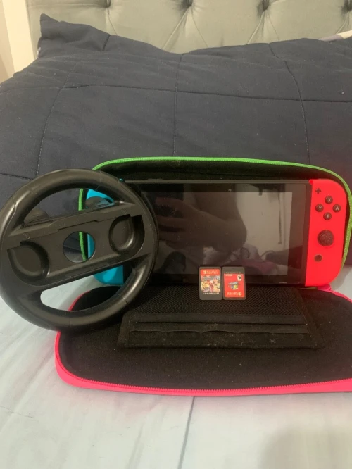 Nintendo switch avec 2 CD (Mario carte 8 delux et Mario odessy) avec une pochette et un volon pour Mario carte