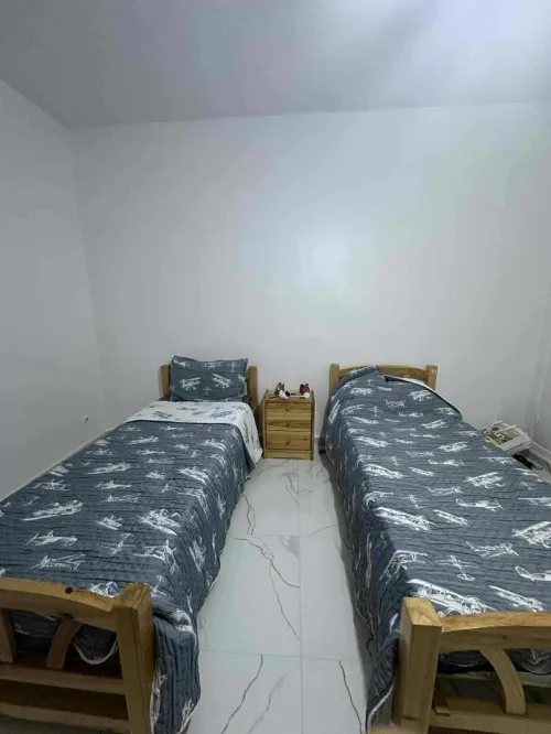 Chambre,2 lits,une table de nuit, un bureau avec la chaise  