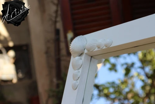 Miroir blanc en bois et coquillages. 