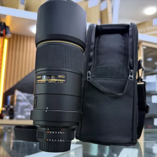 Nikon 300mm f4 en excellent etat comme neuf avec deux bouchons parasoleil .
